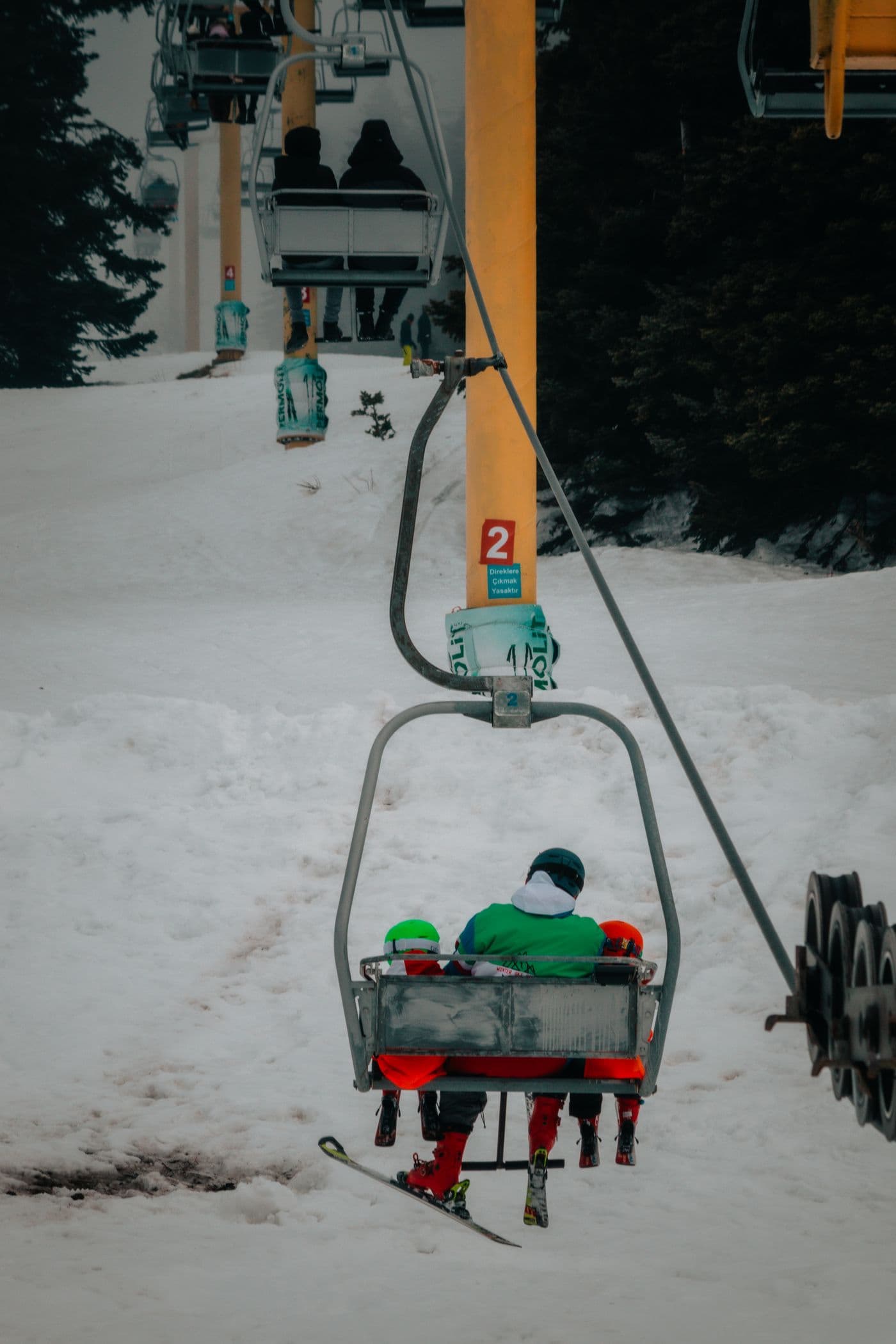 Guests riding a chairlift above the snow