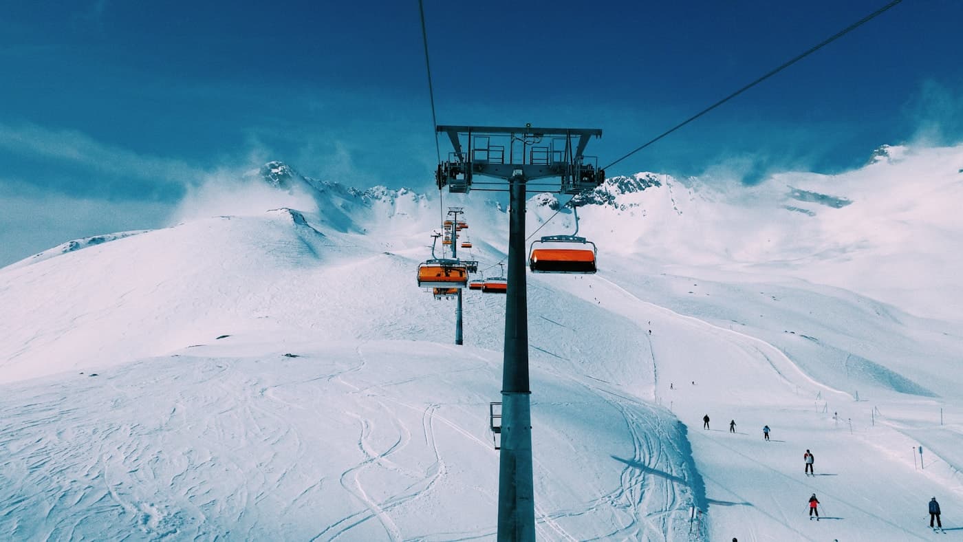 Chairlifts travelling above a snowy ski slope