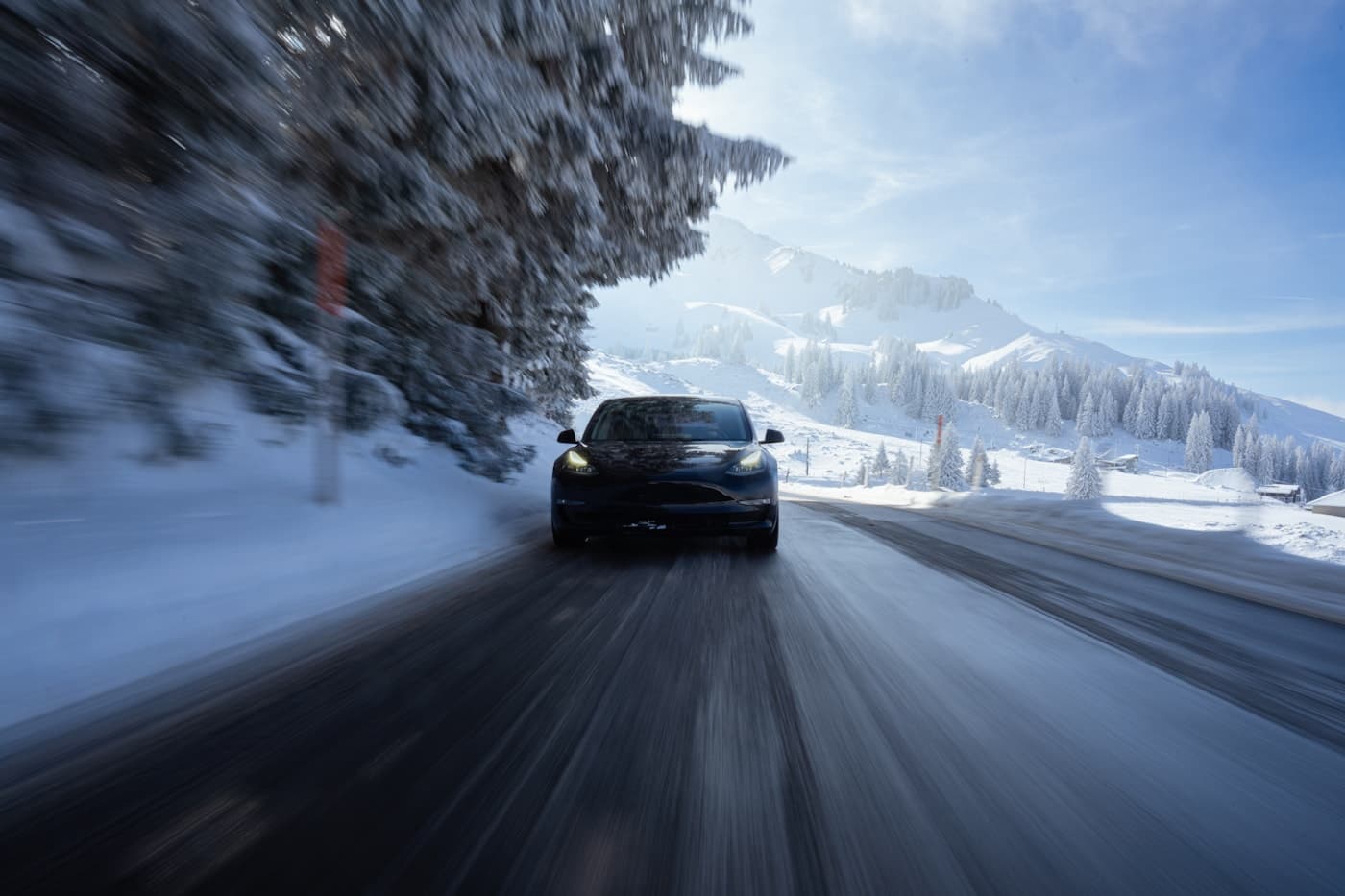 A vehicle driving along a snow-covered mountain road